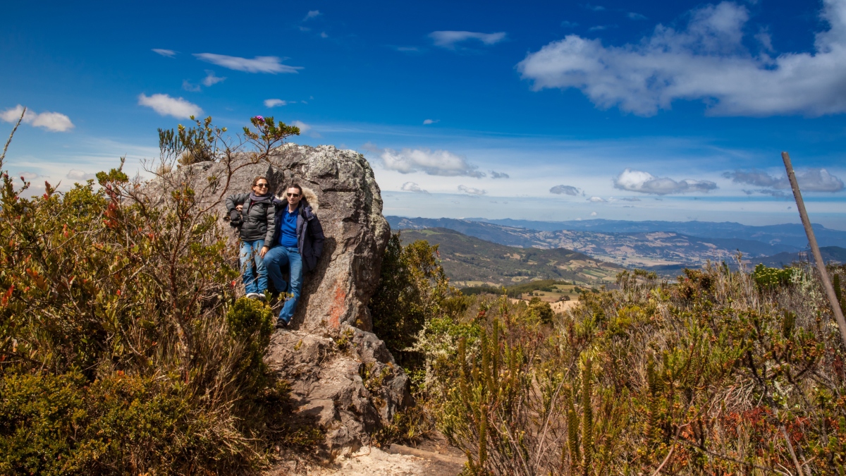 Familia en lo alto de una montaña y atrás vista panorámica del paisaje Foto Getty Images