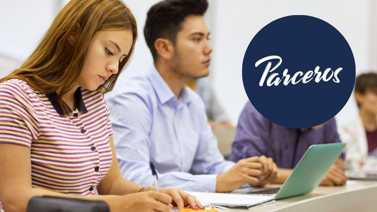 Jóvenes estudiando en una clase mientras usan un computador