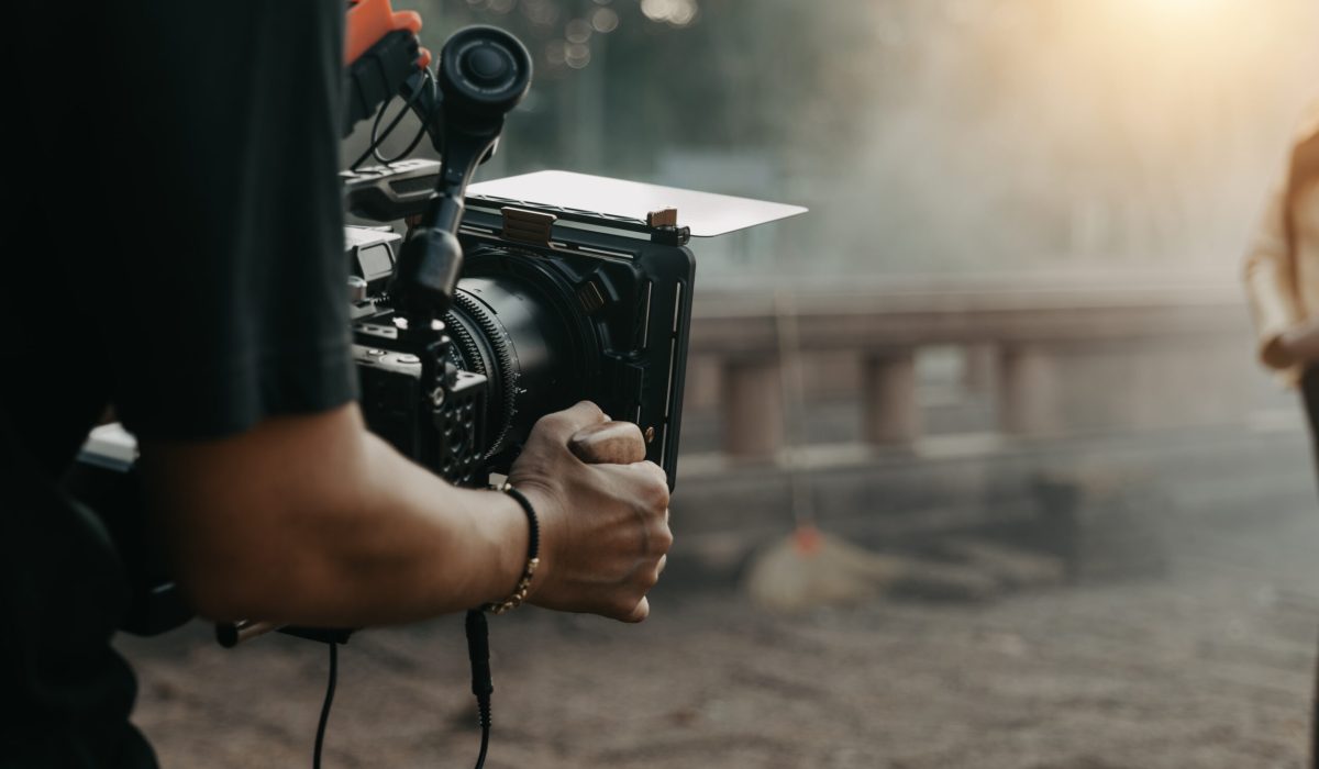 Close up hands holding cinema camera shooting