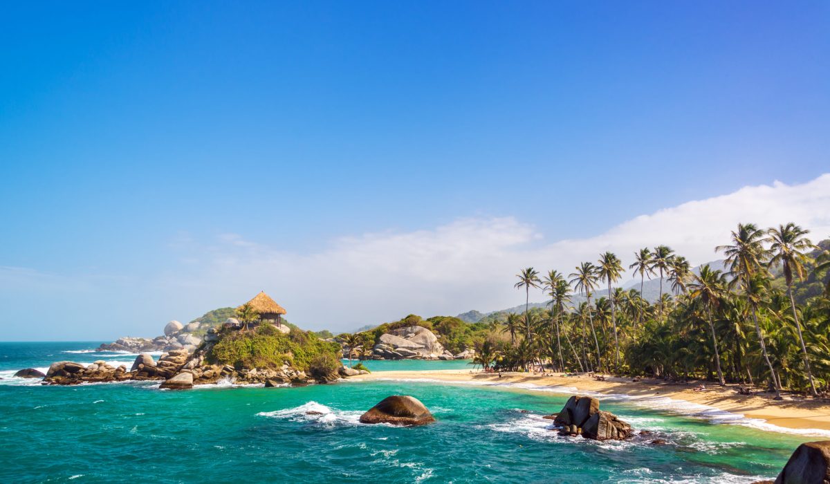 Palm trees and blue Caribbean water on the beach of San Juan del Guia in Tayrona National Park in Colombia